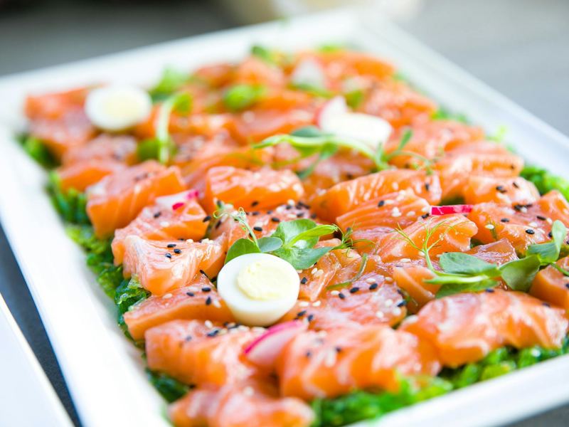 delicious salmon sashimi garnished with quail eggs and fresh greens on image